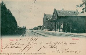 Blick auf das Empfangsgebäude und die Gleise des Bahnhofs Rastede auf einer 1899 gelaufenen Ansichtskarte.